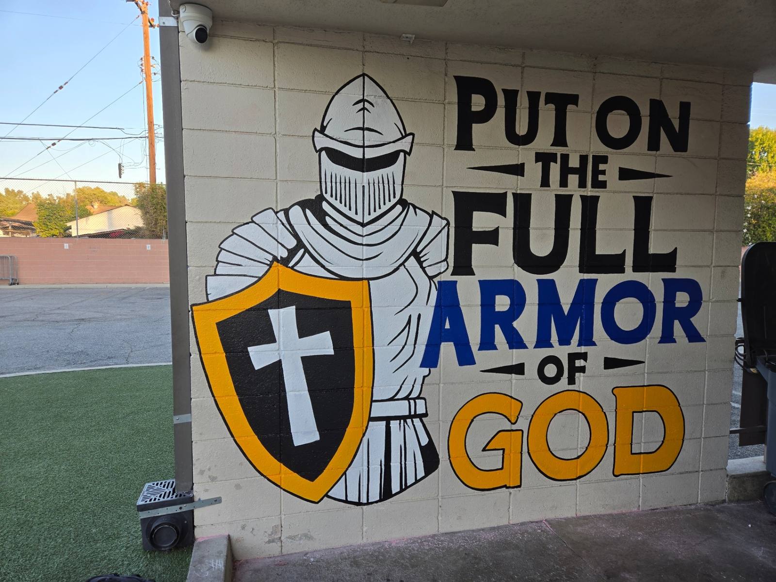 Hand-painted knight in full armor of God mural with shield and cross on a children's ministry wall
