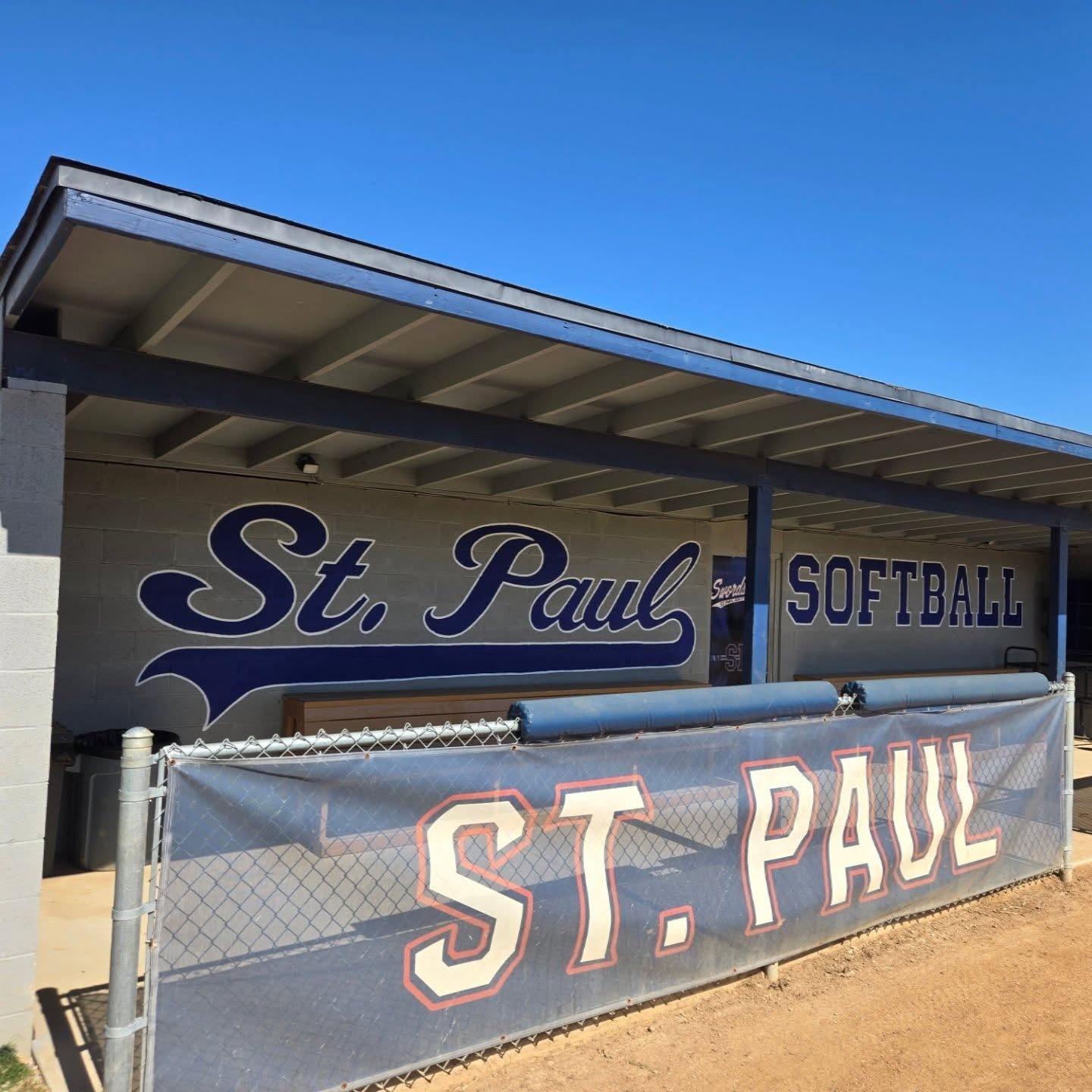Hand-painted St. Paul Softball script lettering on a dugout wall